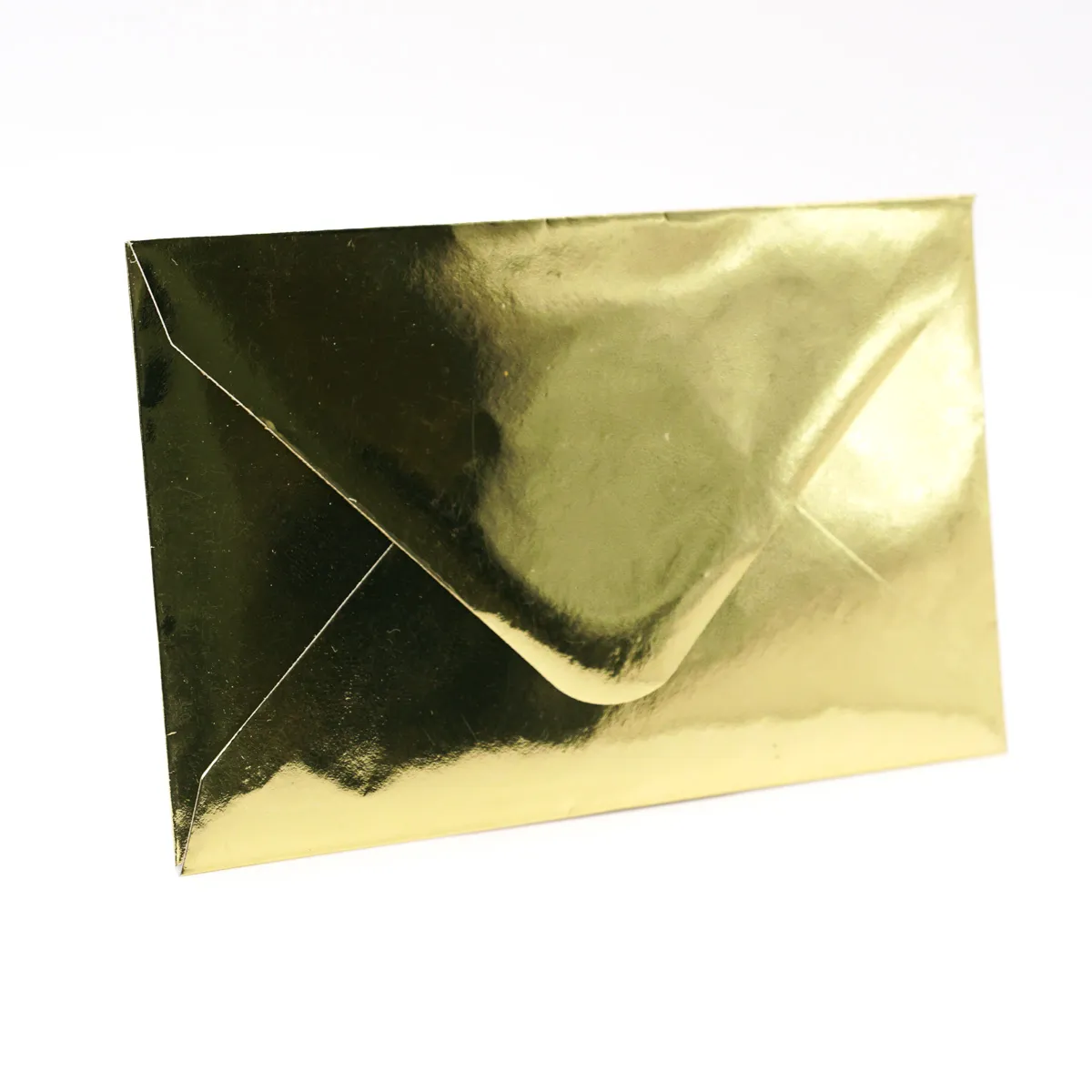 Ein einzelner, geschlossener Briefumschlag mit glänzender, goldener Folienoberfläche auf rein weißem Hintergrund. Der Umschlag steht leicht angewinkelt im Querformat und zeigt seine Rückseite mit spit