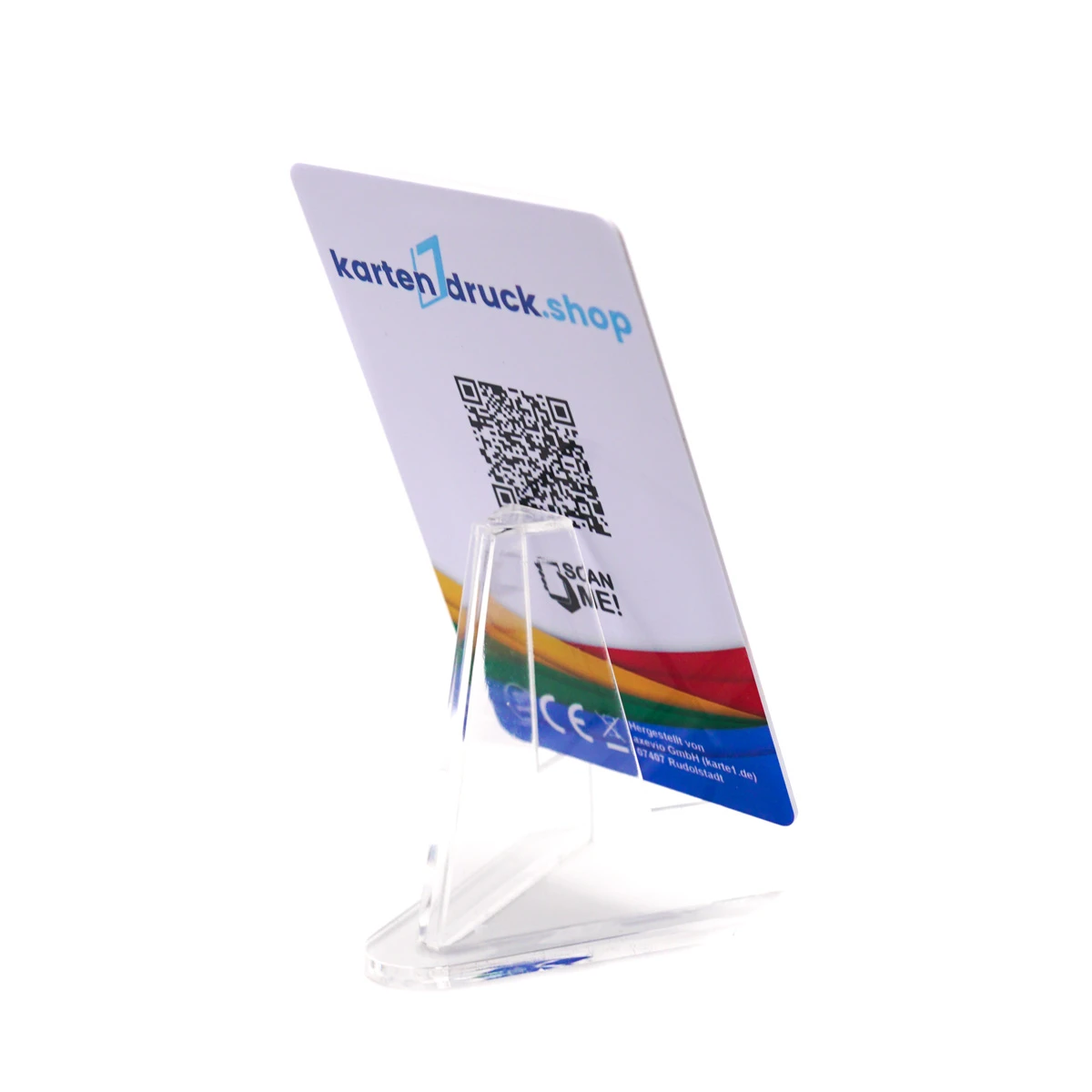 Eine kleine, glasklare Acryl-Staffelei auf weißem Hintergrund, auf der eine bedruckte Plastikkarte schräg von hinten zu sehen ist. Auf der Rückseite der Karte befindet sich oben das Logo „kartendruck.shop“, darunter ein zentraler QR-Code mit dem Hinweis…