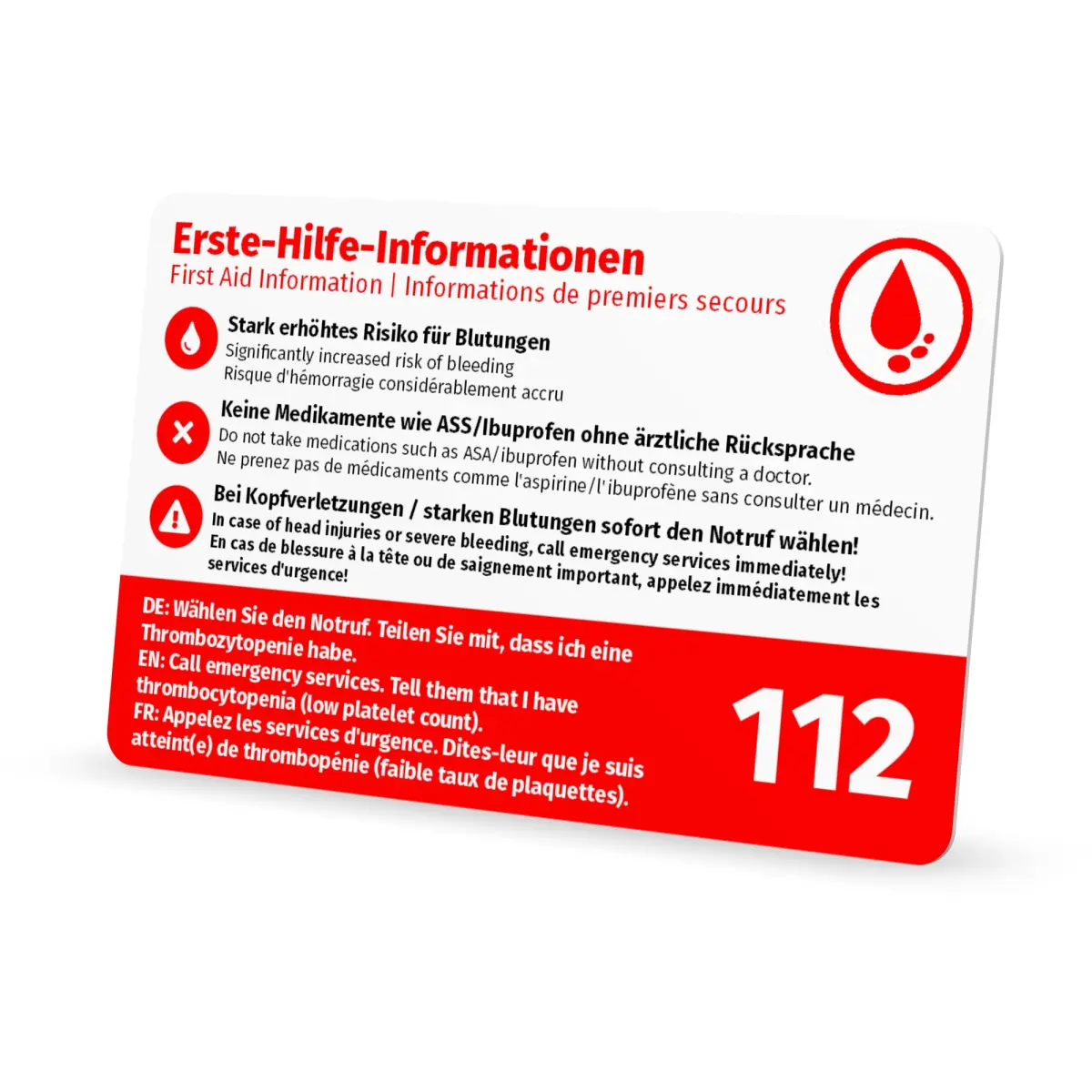 Schrägansicht der Rückseite einer weiss-roten Notfallkarte mit dreisprachigen Erste-Hilfe-Hinweisen, Warnsymbolen und der Notrufnummer 112 vor weissem Hintergrund.